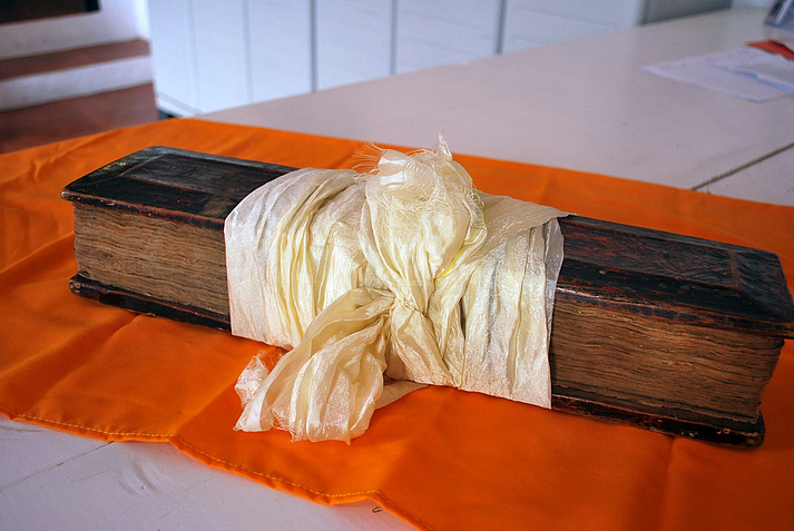 A traditional Tibetan book (dpe cha): Loose leaves placed between wooden cover plates, bound together with a cloth